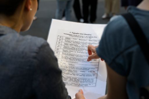 Zwei Frauen studieren das ausgehändigte Bildmaterial.