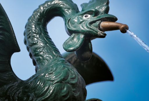 Nahaufnahme eines Basilisken-Brunnen am Rhein