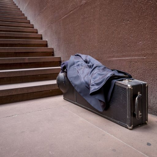 Nahaufnahme Musikfestival Em Bebbi sy Jazz: Musikkoffer, Blazer darüber gelegt, vor einer Treppe aus Sandstein stehend