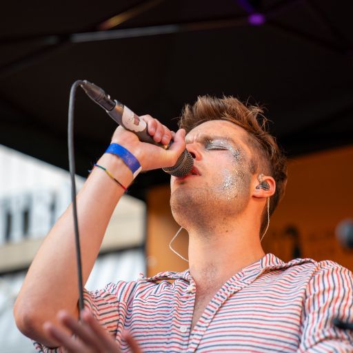 Nahaufnahme Musikfestival Em Bebbi sy Jazz: Musiker der Singt, mit Mikrophon in der Hand, Glitzerschmincke im Gesicht